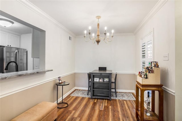 interior space featuring an inviting chandelier, dark wood-type flooring, and ornamental molding