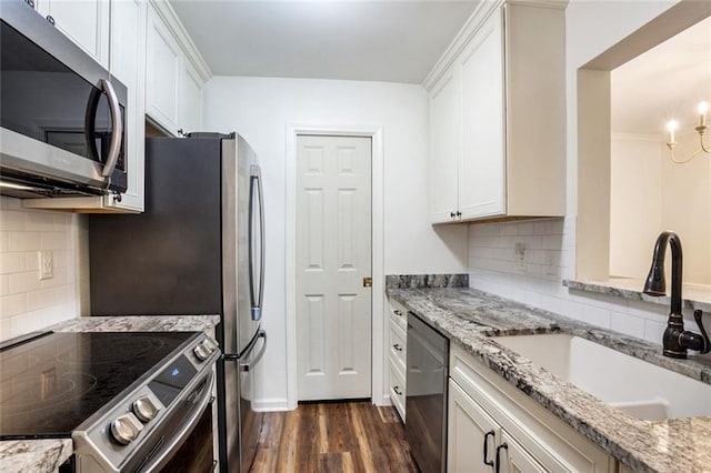 kitchen with backsplash, stainless steel appliances, and white cabinetry