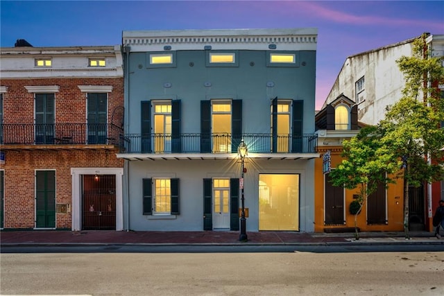 back house at dusk with a balcony