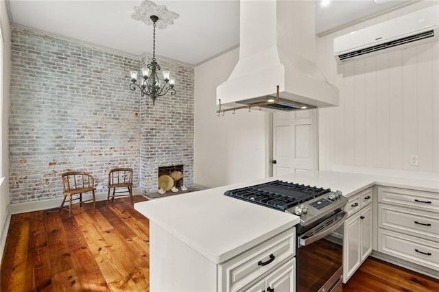 kitchen with island exhaust hood, kitchen peninsula, dark hardwood / wood-style flooring, high end stainless steel range oven, and white cabinets