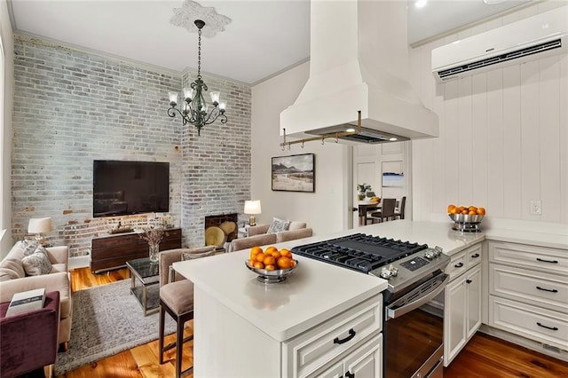 kitchen with white cabinets, a breakfast bar, high end range, and island exhaust hood