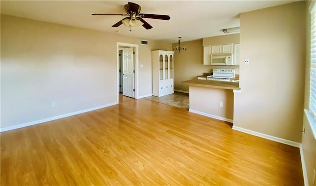 kitchen featuring white appliances, light hardwood / wood-style floors, and ceiling fan with notable chandelier