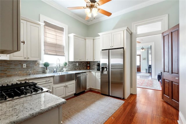 kitchen featuring white cabinetry, light hardwood / wood-style flooring, ceiling fan, and stainless steel appliances