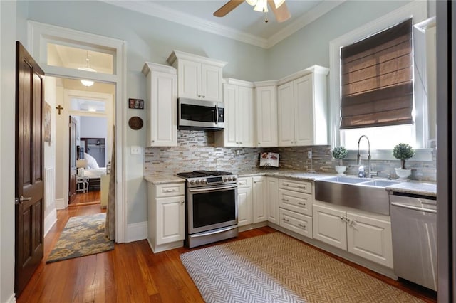 kitchen with white cabinetry, appliances with stainless steel finishes, and light hardwood / wood-style floors