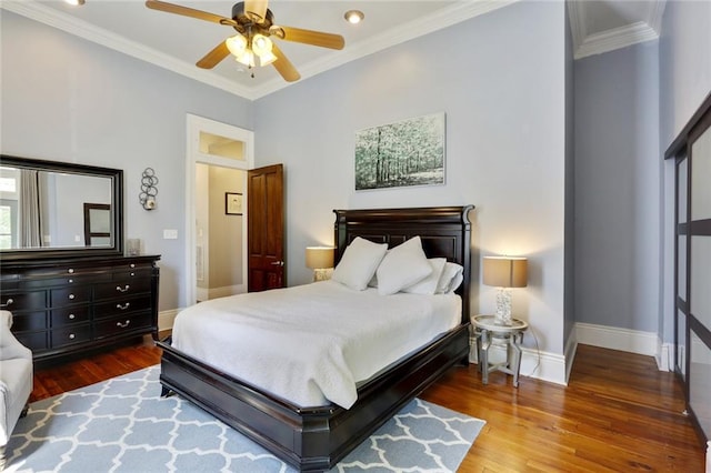 bedroom with ornamental molding, ceiling fan, and dark wood-type flooring