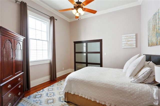 bedroom with ornamental molding, ceiling fan, hardwood / wood-style floors, and multiple windows