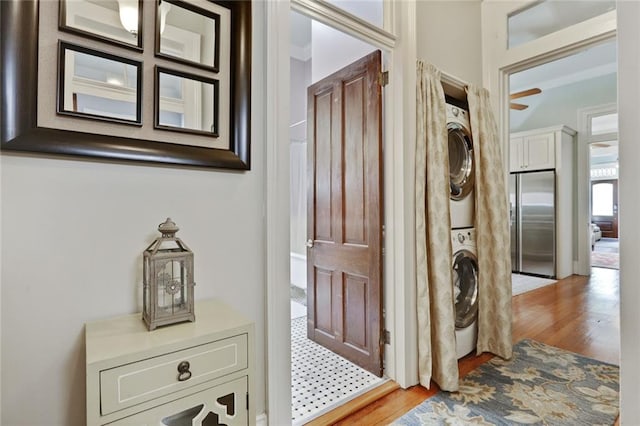 doorway to outside with stacked washing maching and dryer and light wood-type flooring