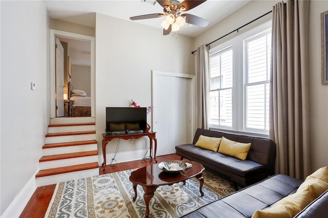 living area featuring ceiling fan, wood-type flooring, and a healthy amount of sunlight