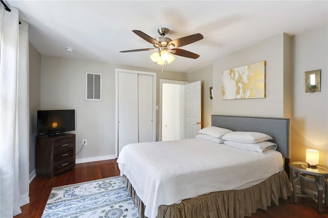 bedroom with ceiling fan, dark wood-type flooring, and a closet