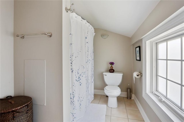 bathroom with tile floors, toilet, and vaulted ceiling