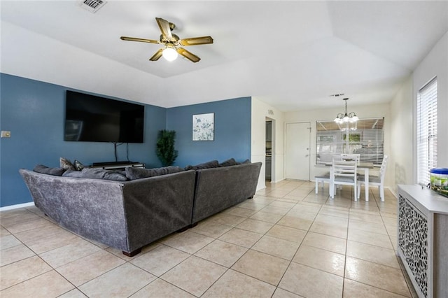 living room with ceiling fan with notable chandelier and light tile floors