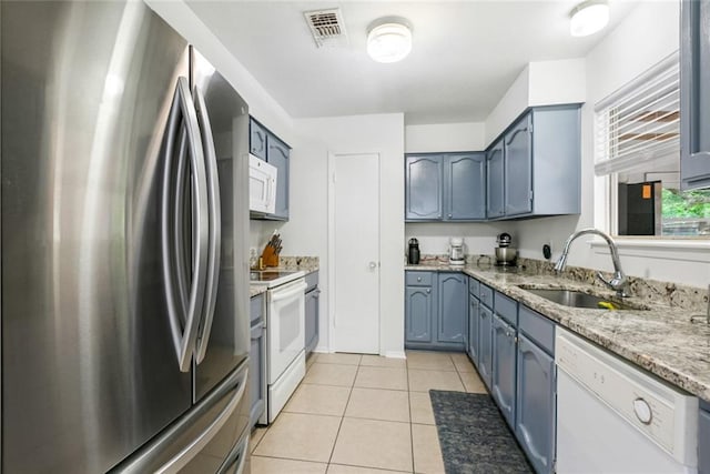 kitchen featuring sink, white appliances, light tile floors, and light stone countertops