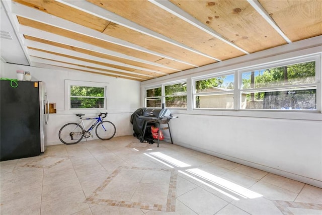 unfurnished sunroom featuring plenty of natural light and vaulted ceiling