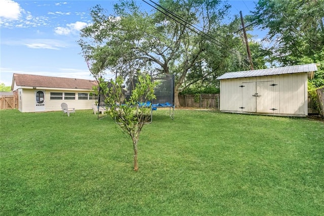 view of yard with a trampoline and a storage unit