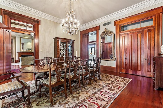 dining room with crown molding, dark hardwood / wood-style floors, and a notable chandelier