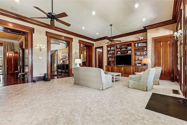 tiled living room with built in shelves, ornamental molding, and ceiling fan with notable chandelier