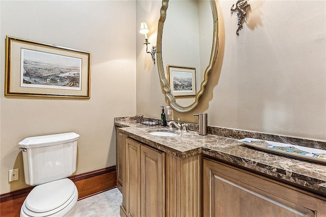 bathroom featuring toilet, tile floors, and vanity