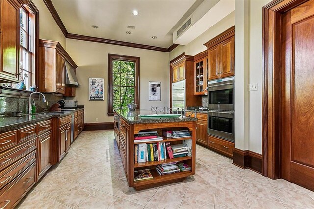 kitchen featuring backsplash, light tile floors, appliances with stainless steel finishes, and sink