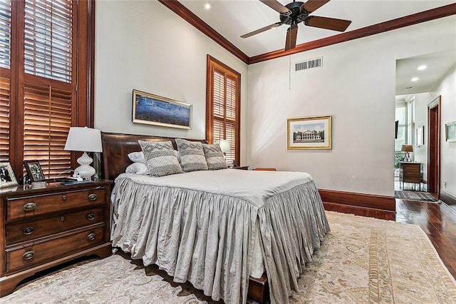 bedroom featuring ceiling fan, crown molding, dark hardwood / wood-style floors, and multiple windows