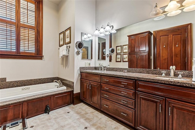 bathroom with tile floors, vanity with extensive cabinet space, double sink, and a tub