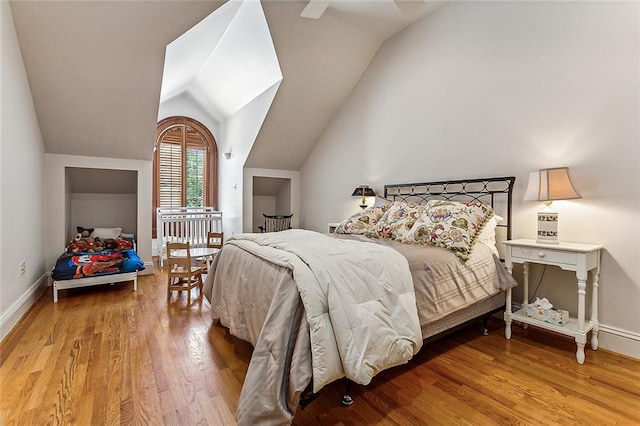 bedroom featuring lofted ceiling, ceiling fan, and light wood-type flooring