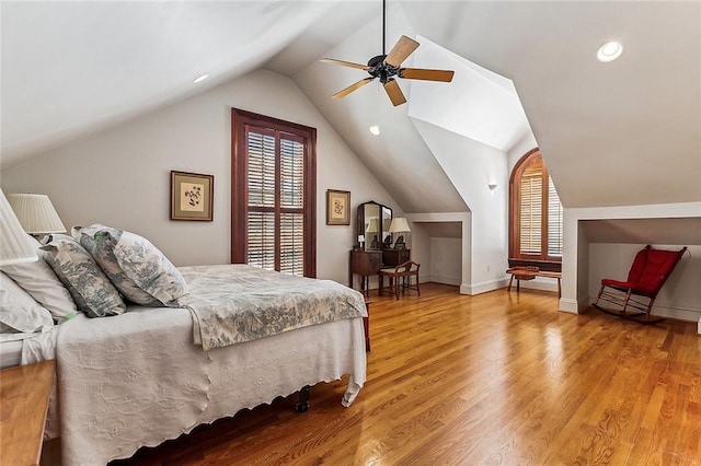 bedroom with multiple windows, ceiling fan, vaulted ceiling, and light wood-type flooring