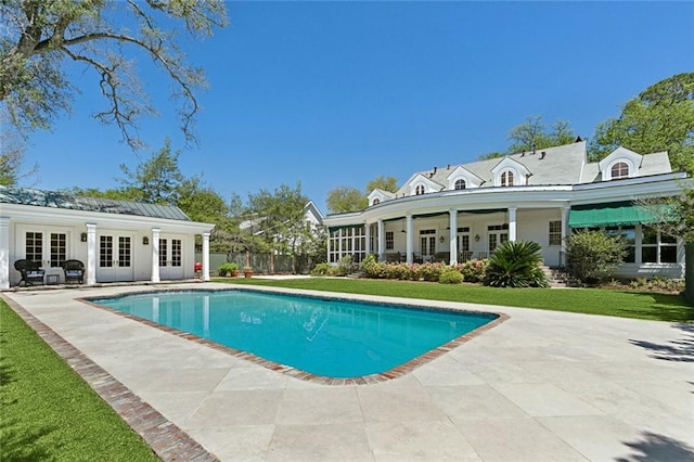 view of swimming pool with a patio area, a yard, and french doors