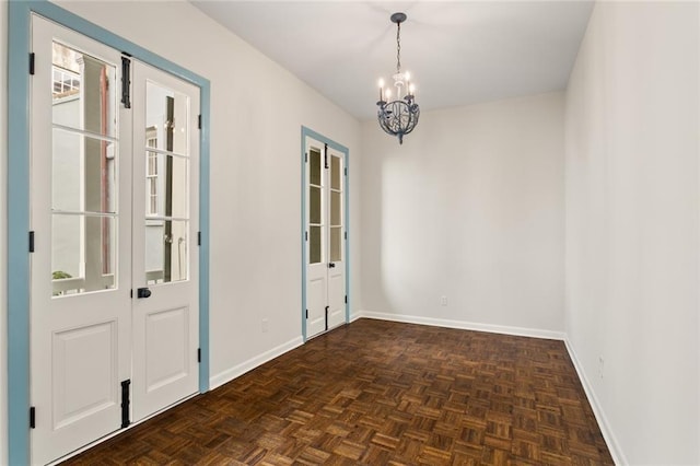 empty room with dark parquet flooring and an inviting chandelier