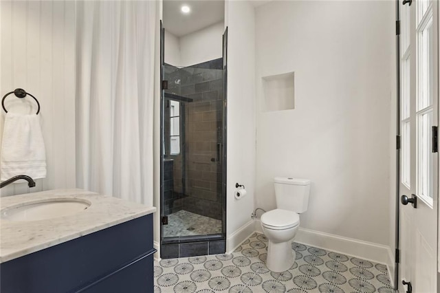 bathroom featuring a shower with door, vanity, a healthy amount of sunlight, and toilet