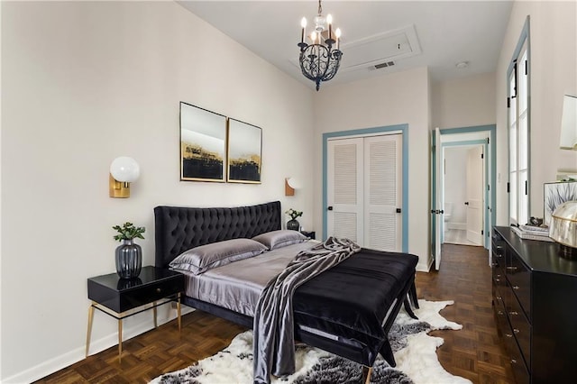 bedroom with dark parquet floors, an inviting chandelier, and a closet