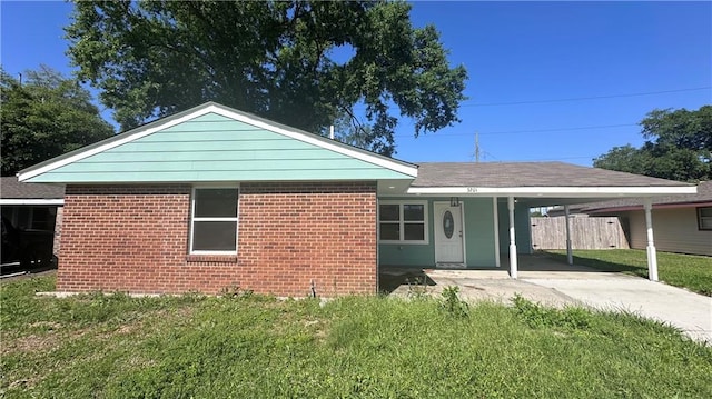 view of front of property featuring a carport and a front yard