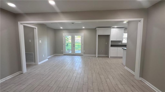 unfurnished living room featuring french doors and light hardwood / wood-style floors