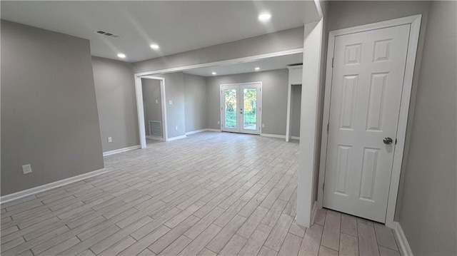 empty room with light hardwood / wood-style floors and french doors