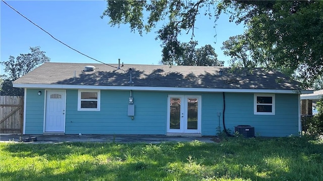 rear view of house featuring a yard, french doors, and central AC