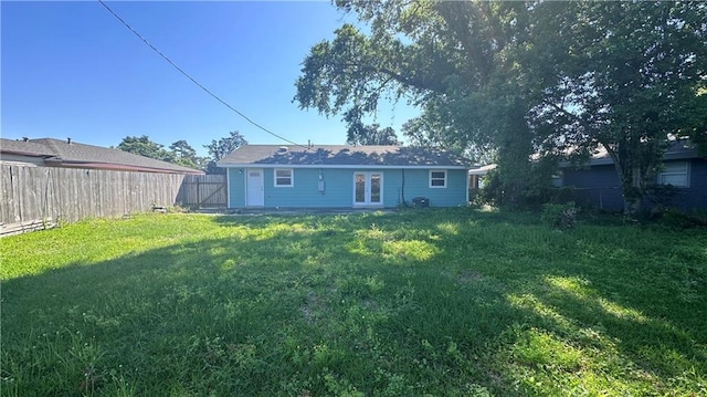 rear view of property with a lawn