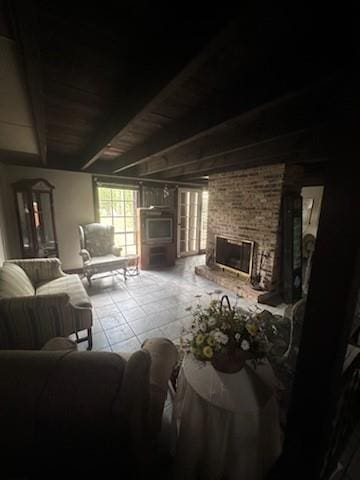 interior space featuring brick wall, a fireplace, and beamed ceiling