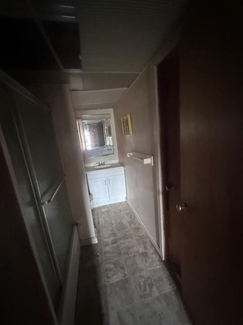 corridor with sink and dark tile floors