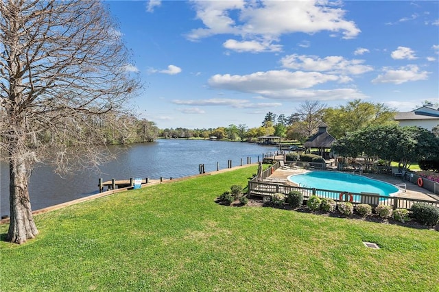 view of dock featuring a fenced in pool, a water view, and a lawn