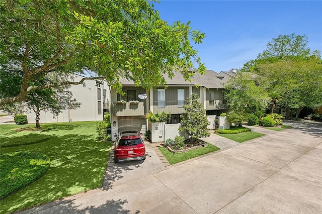 view of front of property featuring a balcony and a front lawn