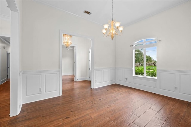 unfurnished dining area featuring an inviting chandelier, wood finished floors, visible vents, and ornamental molding