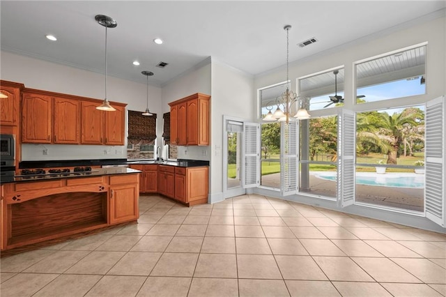 kitchen with dark countertops, visible vents, built in microwave, ornamental molding, and light tile patterned floors