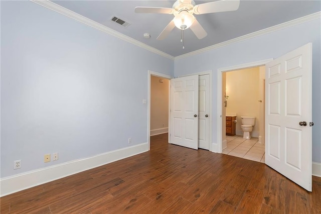 unfurnished bedroom featuring visible vents, ornamental molding, wood finished floors, connected bathroom, and baseboards