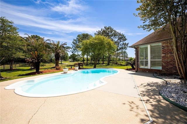 outdoor pool with a patio area and a lawn