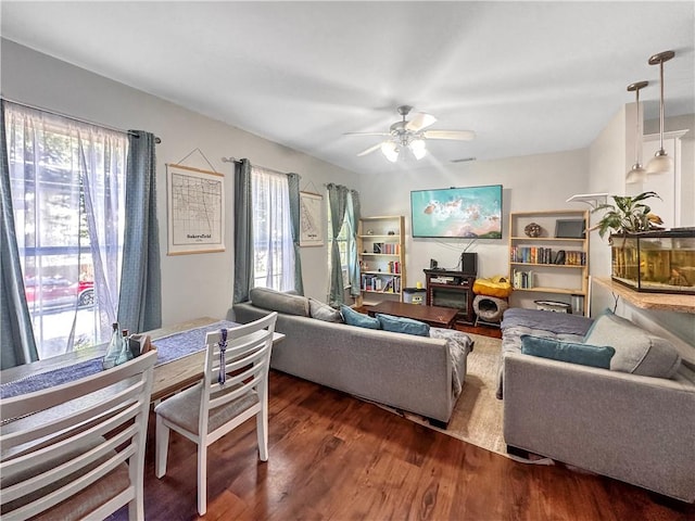 living room with dark hardwood / wood-style flooring, a wealth of natural light, and ceiling fan