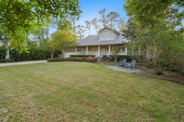 rear view of property with covered porch and a lawn