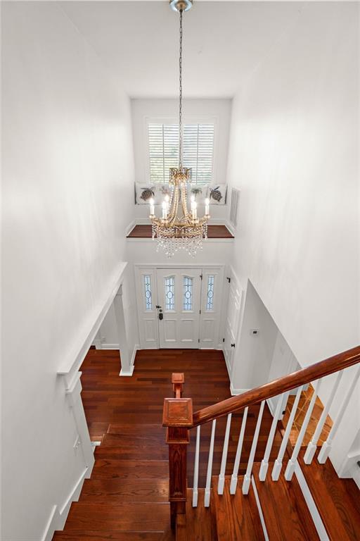 foyer entrance featuring an inviting chandelier and dark hardwood / wood-style flooring