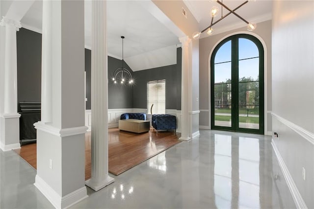 entryway featuring french doors, crown molding, decorative columns, and vaulted ceiling