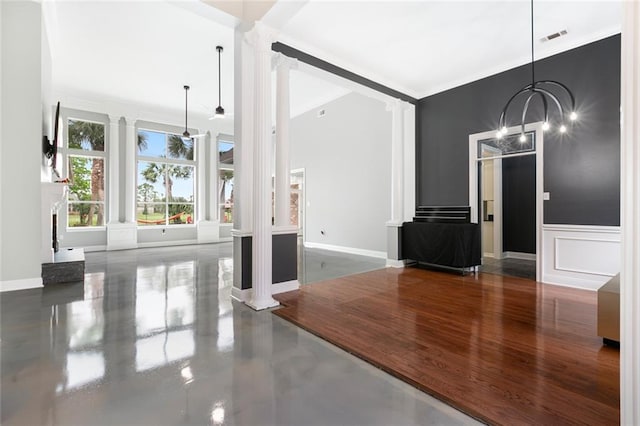 unfurnished living room with an inviting chandelier and decorative columns