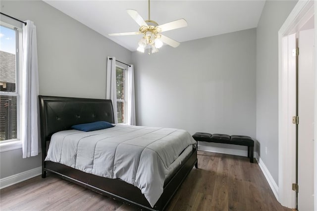 bedroom with dark hardwood / wood-style flooring and ceiling fan