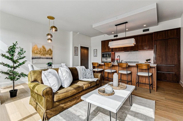 living room featuring sink and light wood-type flooring